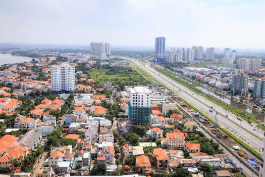 A vibrant aerial view showcasing an urban skyline with orange roofs and highways stretching across the cityscape.