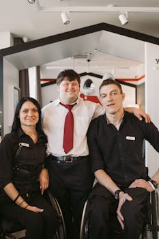 Three colleagues with disabilities enjoying a moment at their workplace, showcasing teamwork and diversity.